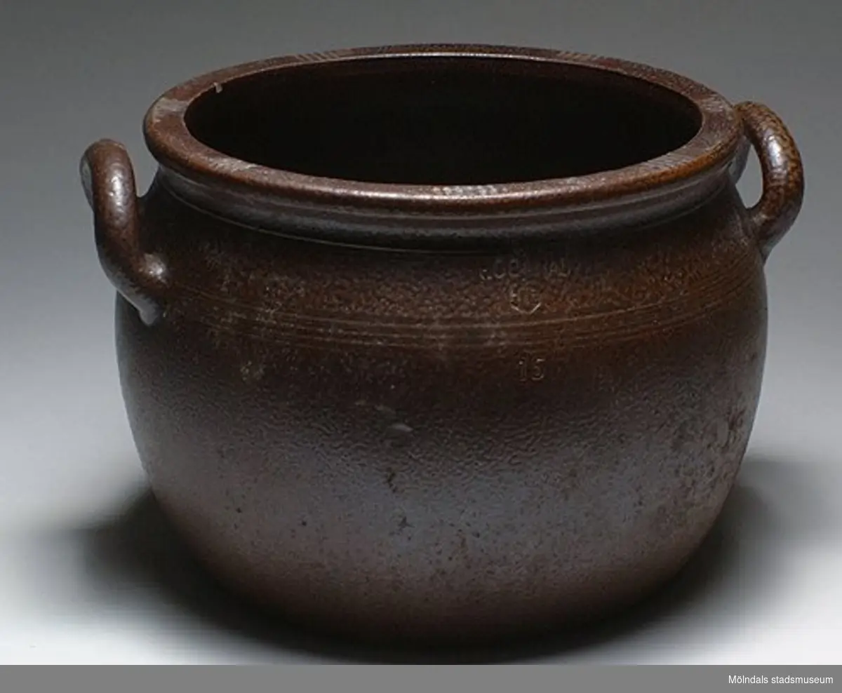 Sex stycken Höganäskrus, i mörkbrunt stengods. MM02271.
:01 Volym: 20 liter. H: 350 mm. Diam: 330 mm. 
:02 Volym: 15 liter. H: 240 mm. Diam. 330 mm.
:03 - 6 Volym: 12 liter. H: 290 mm. Diam: 290 mm.

Från Stretered centralkök. Genom Husmor Elsa Blomstrand.