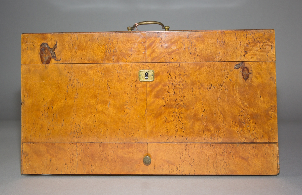 Sockerskrin (A) med lock av masurfanerat trä. Nyckelskylt och handtag av mässing. Låda (B) nertill med knopp av mässing. Skrin och låda med sinkade fogar. Locket på två gångjärn av järn. Invändigt en fast hackkniv med gångjärn av järn med svarvat handtag av trä med mässingsring. Kniven skruvad på tvärgående mellanvägg vilandes på en perforerad innerbotten. 
Med nyckel (C).