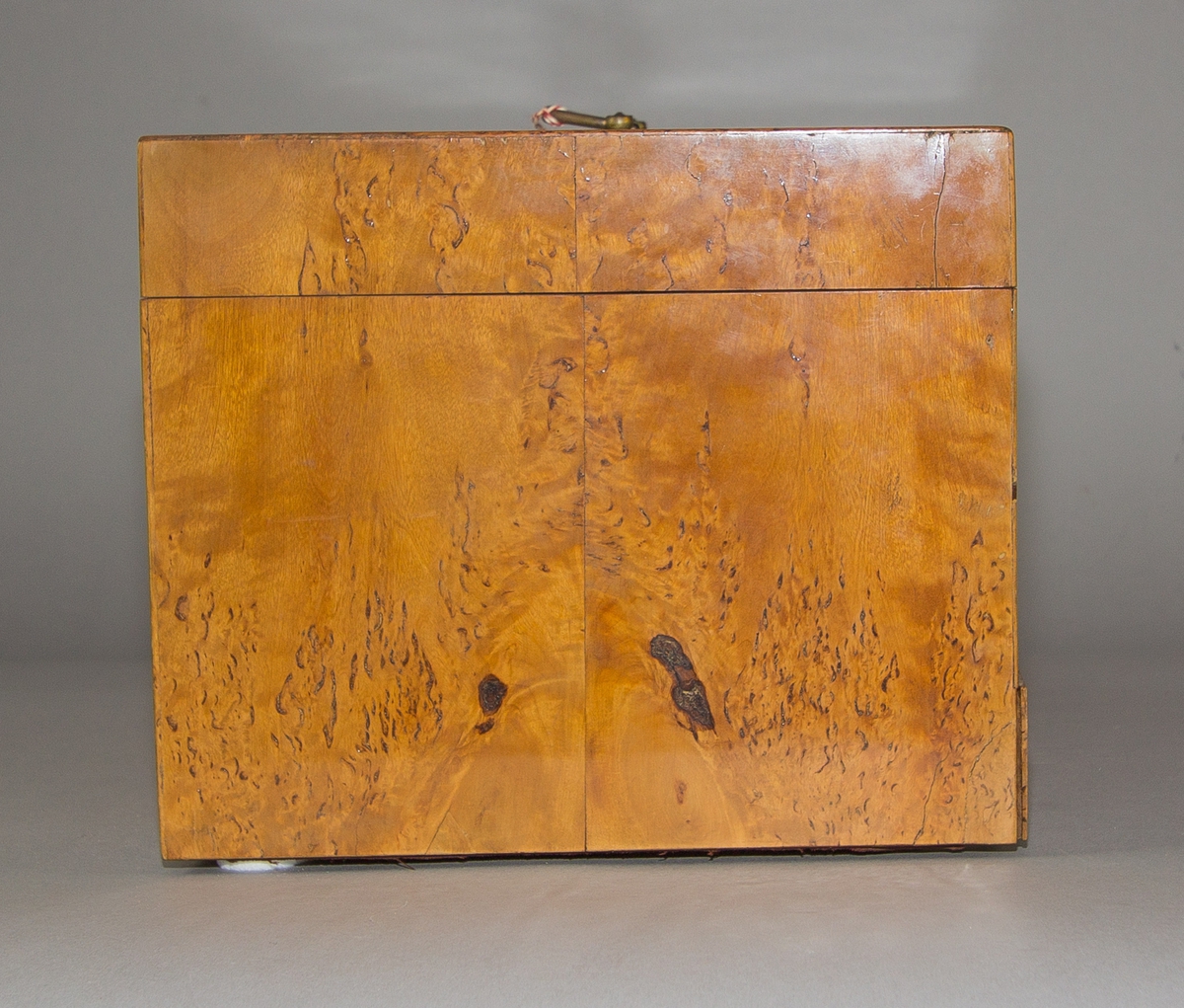 Sockerskrin (A) med lock av masurfanerat trä. Nyckelskylt och handtag av mässing. Låda (B) nertill med knopp av mässing. Skrin och låda med sinkade fogar. Locket på två gångjärn av järn. Invändigt en fast hackkniv med gångjärn av järn med svarvat handtag av trä med mässingsring. Kniven skruvad på tvärgående mellanvägg vilandes på en perforerad innerbotten. 
Med nyckel (C).