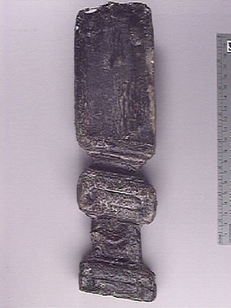 Litet balusterliknande ornament. Långsmalt och snedskuret, med profilerad framsida och slät baksida. Balusterns ena hälft utgörs av en anliggningsyta i form av en slät och odekorerad "tunga". Den andra hälften är dekorerad och utformad i två "sektioner" som avgränsas av en liggande rektangel. Nedtill avslutas den dekorerade delen av en profilerad bas.
Balustern är relativt välbevarad.

Text in English: A small baluster-like ornament. Long and narrow and obliquely cut, with a profiled front and a smooth back. Most of the baluster''s half comprises a surface of attachment, in form of a smooth undecorated "tongue". The other half is decorated and formed in two "sections" separated by a rectangle. The decorated half terminates below in a profiled base.
The baluster is rather well preserved.