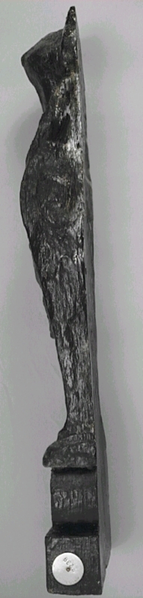 Liten skulpterad pilaster, utformad som en karyatid eller möjligen en putto. Figuren har långt hår och ett knubbigt ansikte, omgivet av en bred krage. Det nedåt avsmalnande pilasterskaftet är dekorerat med akantusblad. Nedtill avslutas pilastern av en rikt profilerad och dekorerad sockel. Skulpturens baksida är slät.
Skulpturen är sliten, främst den övre delen.

Text in English: A small carved pilaster, with a caryatid or probably a putto. The figure has a chubby face, long hair and a broad collar. The lower part of the pilaster is decorated with acanthus leaves. The caryatid stands on a richly profiled and decorated socle. The back of the sculpture is smooth.
The sculpture is worn.