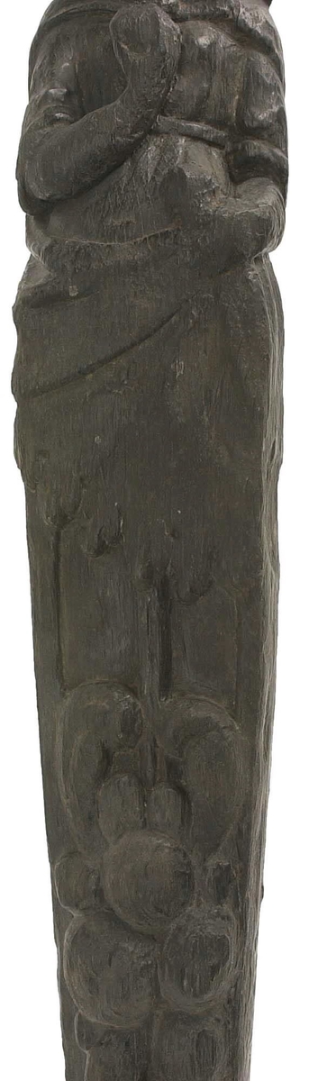 Hermpilaster.

Liten pilaster i form av en karyatid, med långt böljande hår under joniskt kapitäl.

Huvudet är vridet en aning åt höger. Med vänster hand hålls manteln samlad. I höger hand håller figuren en frukt eller dylikt framför bröstet. Pilasterskaftet är prytt med stora frukter och blad, fasthängande vid en stängel som delvis täcker det nedåt avsmalnande skaftets ramverk. Baksidan är slät.

Skulpturen är välbevarad, förutom ansiktet som är kraftigt slitet.

Fyra stycken spikhål, en övertäckt med en plugg.


Text in English: Sculpted small pilaster with a Caryatid with long wavy hair beneath an Ionic capital.

Its head is turned slightly to the right, its left hand holds its gathered mantle. Its right hand holds fruit or the like in front of its brests. The shaft of the pilaster is decorated with fruit and large leaves hanging from a stalk, which partly cover the framing of the tapering shaft. Its back is flat.

The sculpture is somewhat worn, its facial expression has been obliterated.