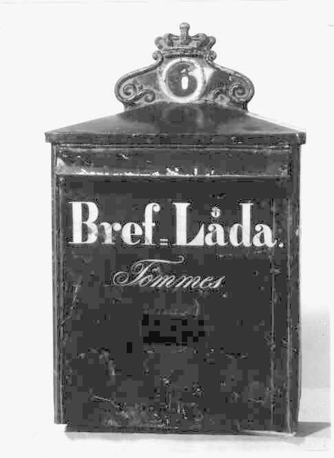 Brevlåda med sluttande tak mot fronten och respektive gavel. Ett postemblem är fäst vid bakstycket på taket. Ett brevinlägg med klaff är placerat i den övre delen av fronten. Under brevlinlägget står texten:"Bref-Låda och därunder "Tömmes". Under texten finns en rektangulär lucka där tömningsturerna skall anges.

Brevlådan töms från botten.