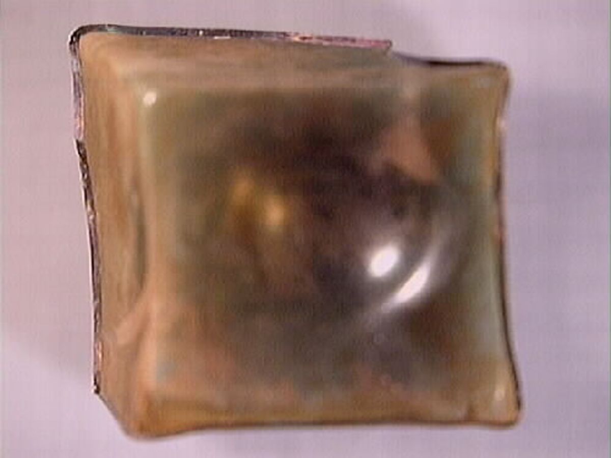 Botten samt fyra skärvor från fyrsidig flaska med stucken botten. På bottnens undersida finns ett puntelmärke. Glaset är grönfärgat och har en iriserande beläggning.

No damage. All pieces are a light green color and are from a case bottle.
10194a: has worn spot
10194c: Consists of two artifact numbers that have been glued together. Artifact has moderate scaling.