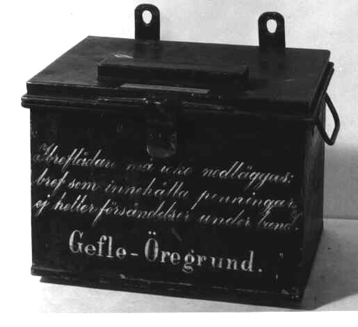Ångbåtsbrevlåda med brevinsläpp i lådans tak. Brevlådantömmes
genom att öppna hela taket. Taket som utgör lådans lock ärlåsbart
medelst hänglås. På lådans bakkant är två upphängningsjärnfästade. På
respektive gavel ett handtag. På fronten texten:Gefle-Öregrund och I
breflådan må icke... På ena gaveln finnsfartygets namn "Gefle".