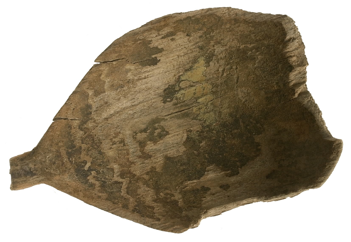 Fyra delar av en träsked. De två större delarna utgör skedskaftet samt större del av skedbladet med ett mindre parti av skaftet. De övriga två delarna utgör fragment av skedblad.

Insidan av skedbladet är dekorerad med ett ristat/glödritat vågmönster. Skedskaftet är kort och rakt, med profilerad skaftände. Längst ut på skaftänden syns en brottyta. Troligtvis har skaftet avlutats i en ändknopp. Skeden har gul-röda utfällningar samt rödbruna färgspår.

Skeddelarna är mycket ömtåliga, med sprickor.

För mer information se Dokumentationsblankett under Referenser – Länkade filer.