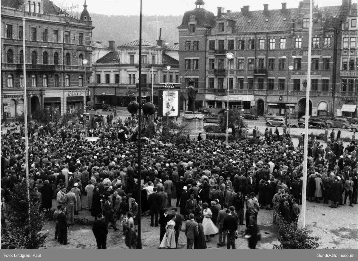 Midsommarnatt på torget. Porträtt, man och kvinna sitter på fönsterbräda, ev inne i Stadshuset.
