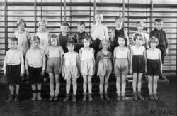 Gruppfoto av flickor och pojkar i gymnastikskläder uppställd