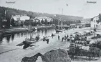 Från vänster Norrmalm, Selångersån och till höger torghandel på Fisktorget. I Selångersån ligger båtar och segelfartyg. Vykort. J. Sunessons Bokhandel förlag.