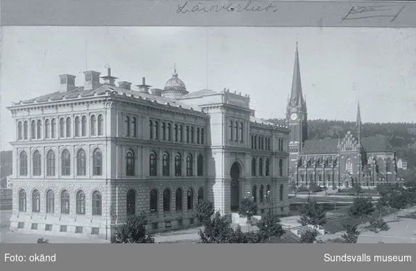 Till vänster läroverket och till höger Skolhusallèn i bakgrunden Gustav Adolfskyrkan. Baksidan av fotot har bland annat texten "J.Sunessons Bokhandel, Sundvall".