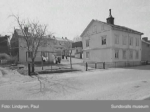 Nygatan 19. Fastigheten uppfördes 1895 av handlaren MAFürst som även där bedrev handelsrörelse(speceriaffär) i det tillhörande huset.Byggnaderna är uppförda av timmer som spönats.1901 sålde Fürst fastigheten till torparen ErikAugust Sjölund som innehade densamma ett par år varefter Fürst åter fövärvade egendommen. 1907 övertogs fastigheten av inspektoren  på Rosenborg,  A.J Berg. Rörelsen drevs fram till första världskriget av fru Johanna Berg.I gårdshuset inrättades en elektrisk mangel,som efter båda makarnas frånfälle övertogs av en dotter och som alltjämt var i full verksamhet. t.o. m. 1960 då även denna nedlades.