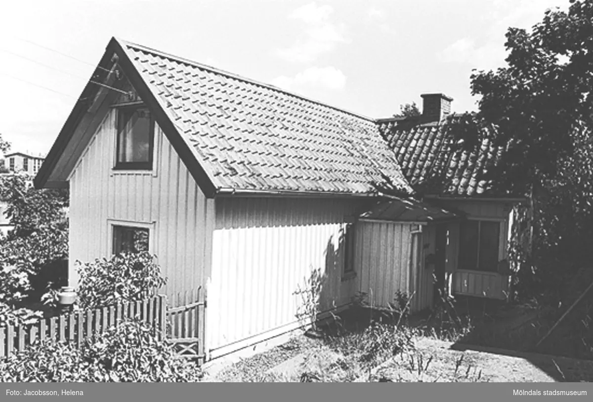 Exteriörbild av bostadshus med förstuga och uthus på Roten M 32 i Mölndals Kvarnby, 1972.