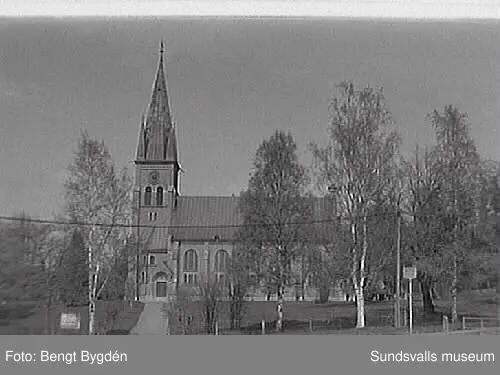 Nya och gamla kyrkan på Alnö, kyrkskolan, hembygdsgården samt intilliggande bebyggelse.