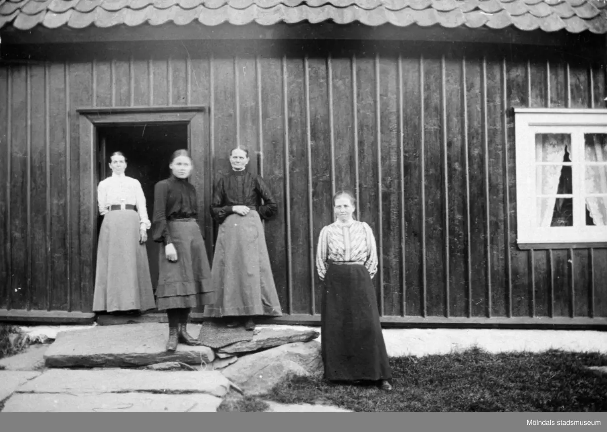 Från vänster står Josefina Eriksson, Valdeborg Johansson, Maria Eriksson och Anna Carlsson vid Olas stuga 1907 - 1910.
Text på baksidan av fotot: "Fr v. Fina, Valdeborg, Maria och Anna".  Anna arbetade som piga hos systrarna Maria och Josefina. De var moster till Valdeborg.