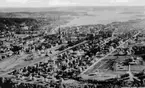 Stadsvy över Sundsvall. Stadsdelarna från förgrunden, Västermalm, Södermalm, Stenstaden, Norrmalm till höger i bakgrunden Sundsvallsfjärden. Troligen 1930 - tal.  Text på vykortet 