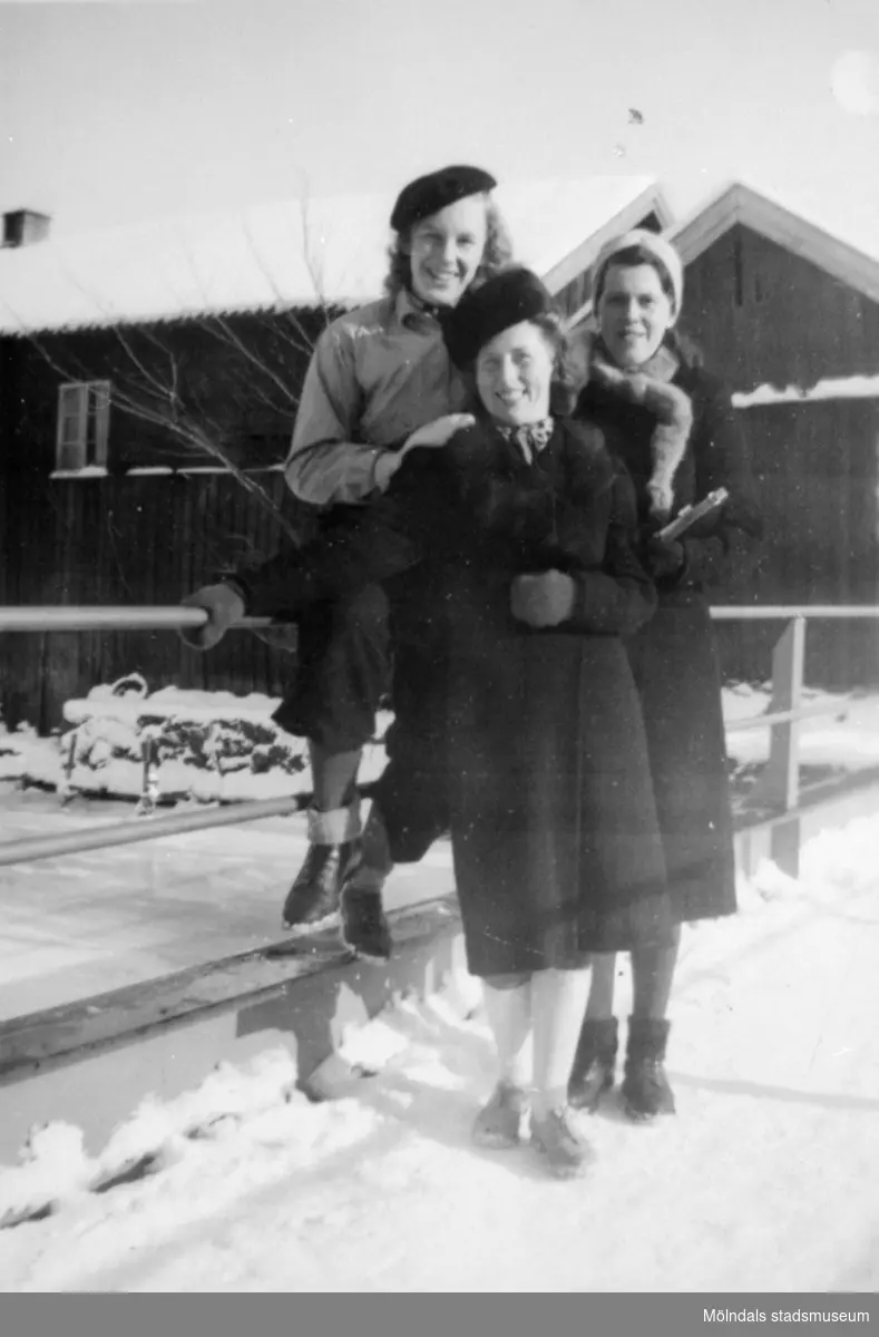 Väninnor tillsammans vid en bro i ett snöklätt Kvarnbyn. 1930-tal. Från vänster: okänd, Astrid Karlsson (gift Garthman) och Karin Karlsson. Givare är sonen Alf Garthman som arbetade många år på Mölndals stadsmuseum.