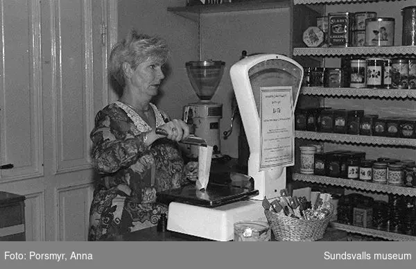 Kaffeaffären IDO, Nybrogatan. Bildsvit gjord för dokumentation utförd 1996. Affärsrörelsen grundades av Carl Dahlström den 18 november 1931. Dahlström föddes i Närsta, Alnö. Han arbetade som kassör på Hörningsholms sågverk 1918 till 1930 då sågen lades ner. Han fick inspirartion att starta kaffehandeln av sin bror Erland som arbetade på Kolonialvaruaktiebolaget. Mellan 1931 till 1937 drev Dahlström kaffehandeln tills en anställd, Eva Farm, tog över som nästa ägare. Sune Bäckström som tidigare arbetat som springpojke på firman tog över verksamheten 1954. Rosteriet som tidigare låg i magasinskvarteren (nuvarande Kulturmagasinet) flyttades 1983 till innergården vid Blombergska huset och en specialbyggd skorsten fick uppföras. Tonvikten på försäljningen ligger numera (2020) på ett välsorterat utbud av olika tesorter.