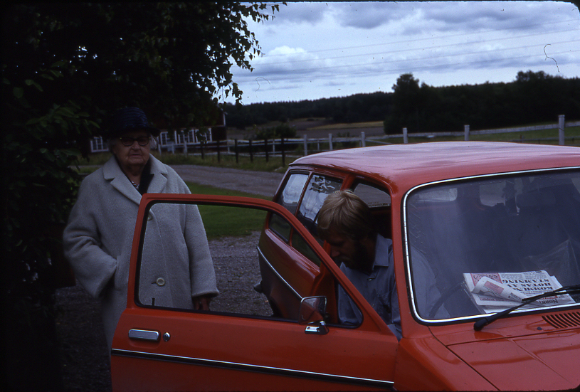 Lantbrevbäraren Mikael Mattsson träffar här Adele Nilsson i Rörby.Han sitter i bilen, hon står vid den öppna bildörren.