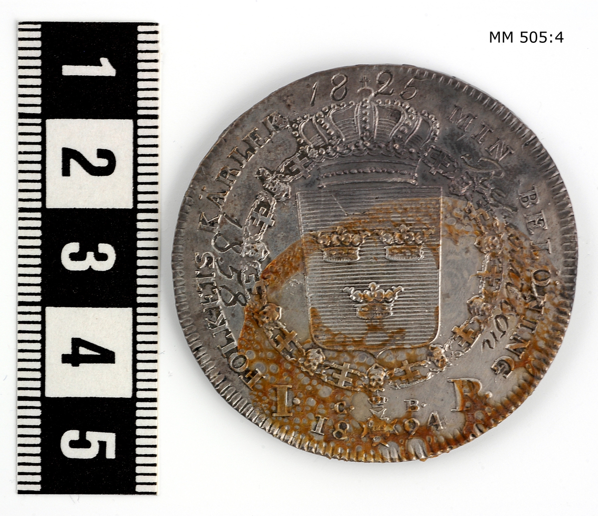 Minnespenning m.m. från slopade fartyg, inplacerade i en glastäckt låda i trä, polerad. Lådan innehåller 17 st penningar och 3 kopparplattor, de senare märkta med årtalen 1857, 1858 och 1861. Lådan innehålelr även diverse handlingar om mynten.