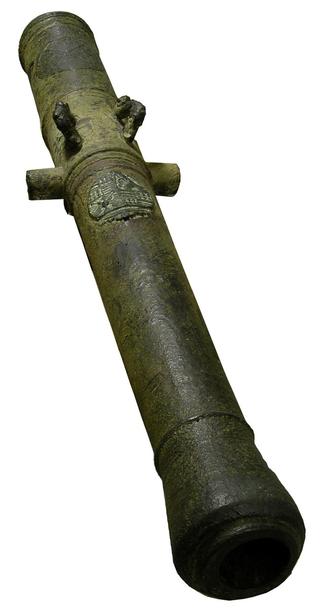 6-pundig kanon av metall gjuten år 1628. Märkt: ett vapen (tyskt?) å långa fältet och ett på kammaren. Vapenskölden på kanonen tillhör grevskapet Mansfeld, ett fordom tyskt grevskap som sedan 1200-talet tillhörde släkten Mansfeld. Ätten utslocknade på svärdssidan år 1780 då området införlivades dels med Sachsen, dels med Preussen, som 1815 erhöll även den Sachsiska delen. Kanonen uppfiskades från sjöbottnen vid Flaggskär i Blekinge skärgård år 1887 av några fiskare och inlöstes av Karlskrona örlogsvarv för ett belopp av 500 kr år 1888. (Se W.C.K. resor s. 3445/88). Ritning finns i portfölj P.I. Litt. Ba Nr 313. Fiskaren var 12 år gammal och hette Sjöberg.