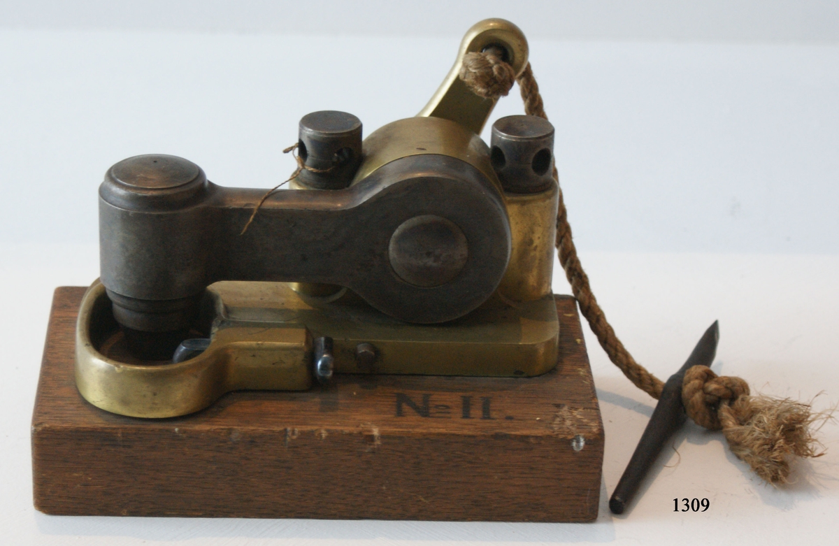 Kanonlås av järn och metall, modell av Sasse. Fastsatt till en träklots (Nr 2).