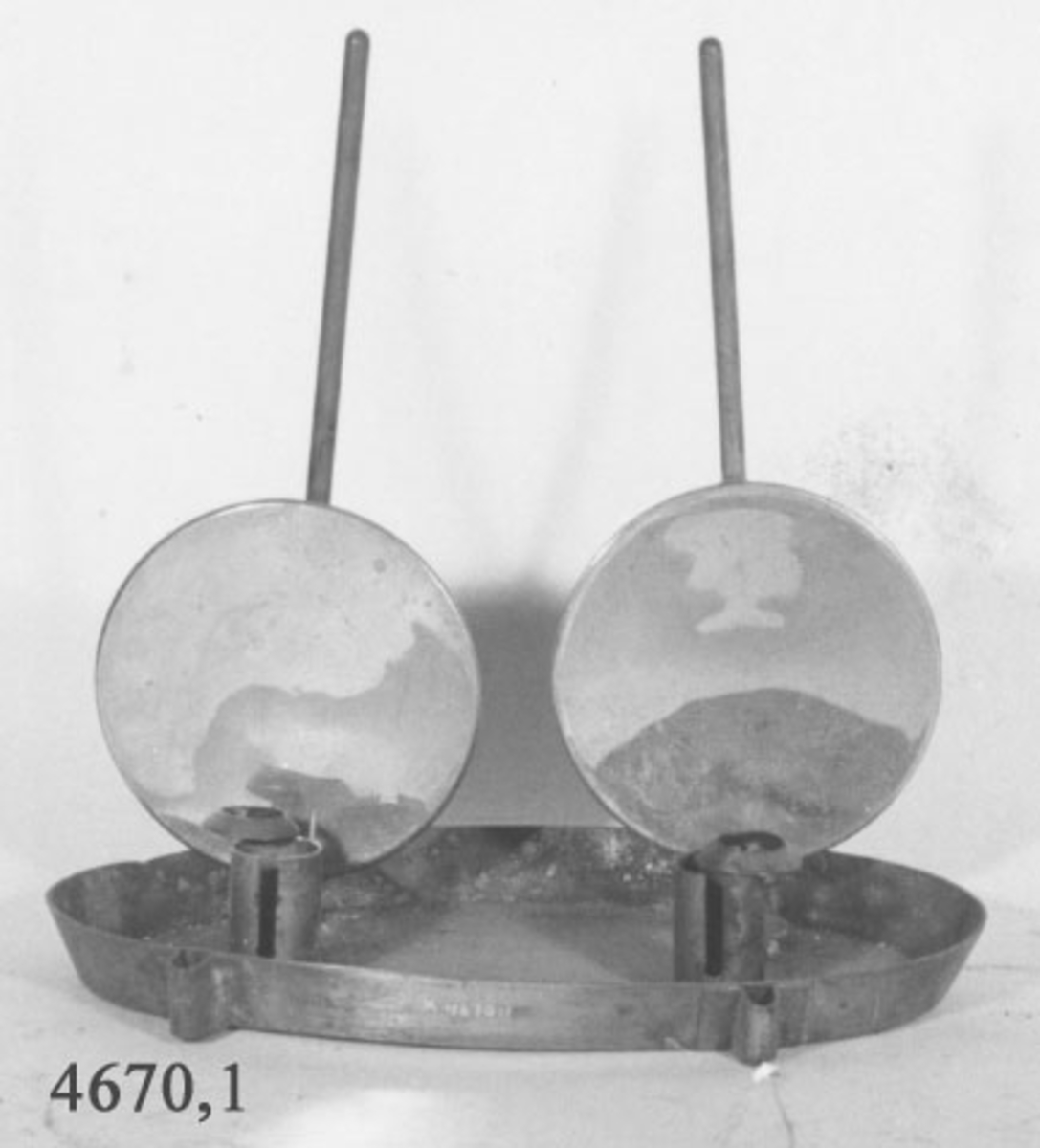 Ljusstake till blysa för ammunitionsdurk. Av mässing och ovalformad. Staken försedd med två stycken ståndare med reflektorer, förnicklade.
På reflektorerna armar med bleck till ljuset, så att reflektorerna följer ljuset vid nedbränning.
På yttersidorna finns fyra stycken hylsor för fastsättning i blysan.
Märkt med "Berserk" samt kronstämpel.