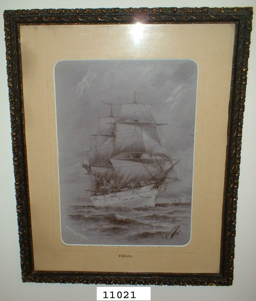 Fotografi inom glas och ram av trä, svart med ornamentering i gult och svart. Visar korvetten Freja till sjöss under segel efter en tavla av C. Törnström år 1900. Fotot märkt: Freja. Korvetten Freja byggd vid Kockums varv år 1885.