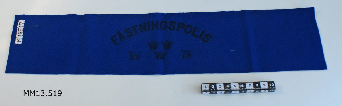 Armbindel. Färg: blå. Märkning i svart: FÄSTNINGSPOLIS NR 78. Tre st. kronstämplar.