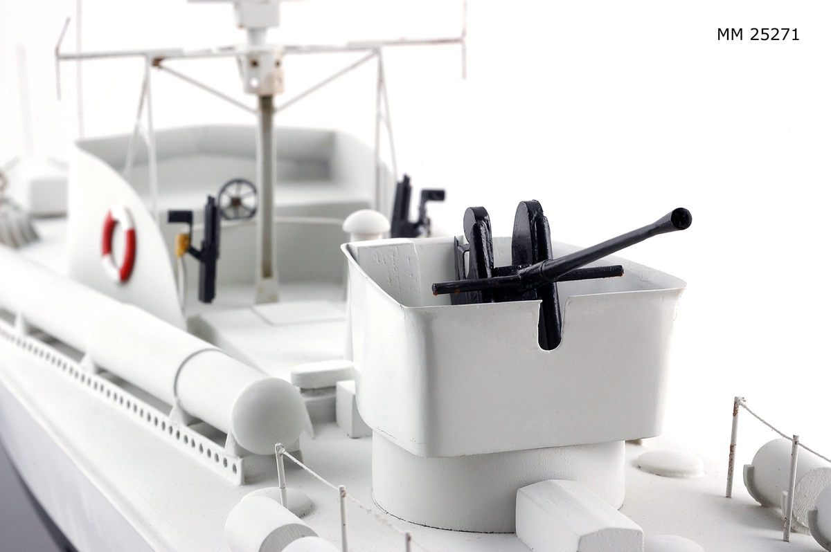 Modell av motortorpedbåten T 32. Från vattenlinjen och neråt målad i svart, från vattenlinjen och uppåt målad i ljusgrått. Märkt på stäven med skuggade bokstäver i guldfärg: "T32". På fördäck står en lysraketkastare och i en upphöjd brunnskonstruktion en dubbel KSP M/36. Mitt på fartyget en brygga med styrratt. På var sida om och bryggans sköldliknande upphöjning sitter en röd och vit frälsarkrans och något akter om dessa dubbellavettage med kulspruta M/36. Akter om bryggan sitter en luftvärnskanon i ett upphöjt brunnslavettage.
Modellen sitter på två konliknande fästen i en glasmonter med svart botten. Dimensioner avser modellen.