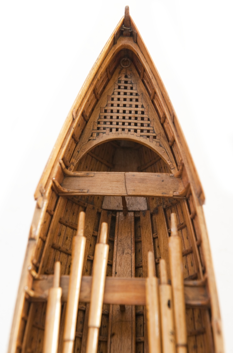 Gigg, bordlagd på spant, klink med fullständig inredning. 6 årtullar, 6 åror. Roder med skädda. Fernissad, Stativ fernissat. Masten saknas.