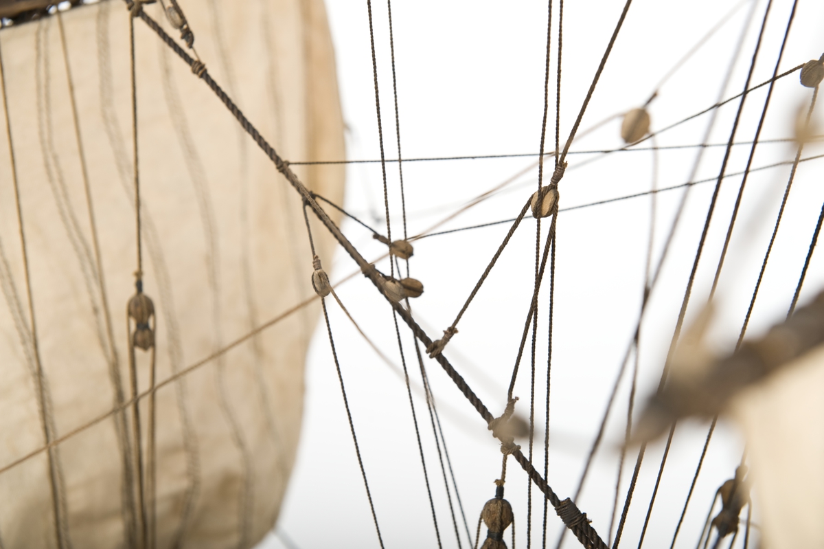 Flöjtskeppsmodell. Riggat med stående och löpande gods, segel av bomull. Bogspröt m. 2 blindor. Fock- o stormast med märs- och undersegel. Latinsegel på mesanmasten. Galjon m. lejon. 2 bogankare, båt på skrå midskeppsöver storluckan. På halvdäck 2 metallkanoner, 4 bogkanoner, samt 4 kanoner på låringen. 1 campagnelykta. Mörkbetsat skrov med 2 svarta berghult, svart bottenfärg. Akterspegel rikt ornerad med 6 fönster. Föremålets form: Helmodell