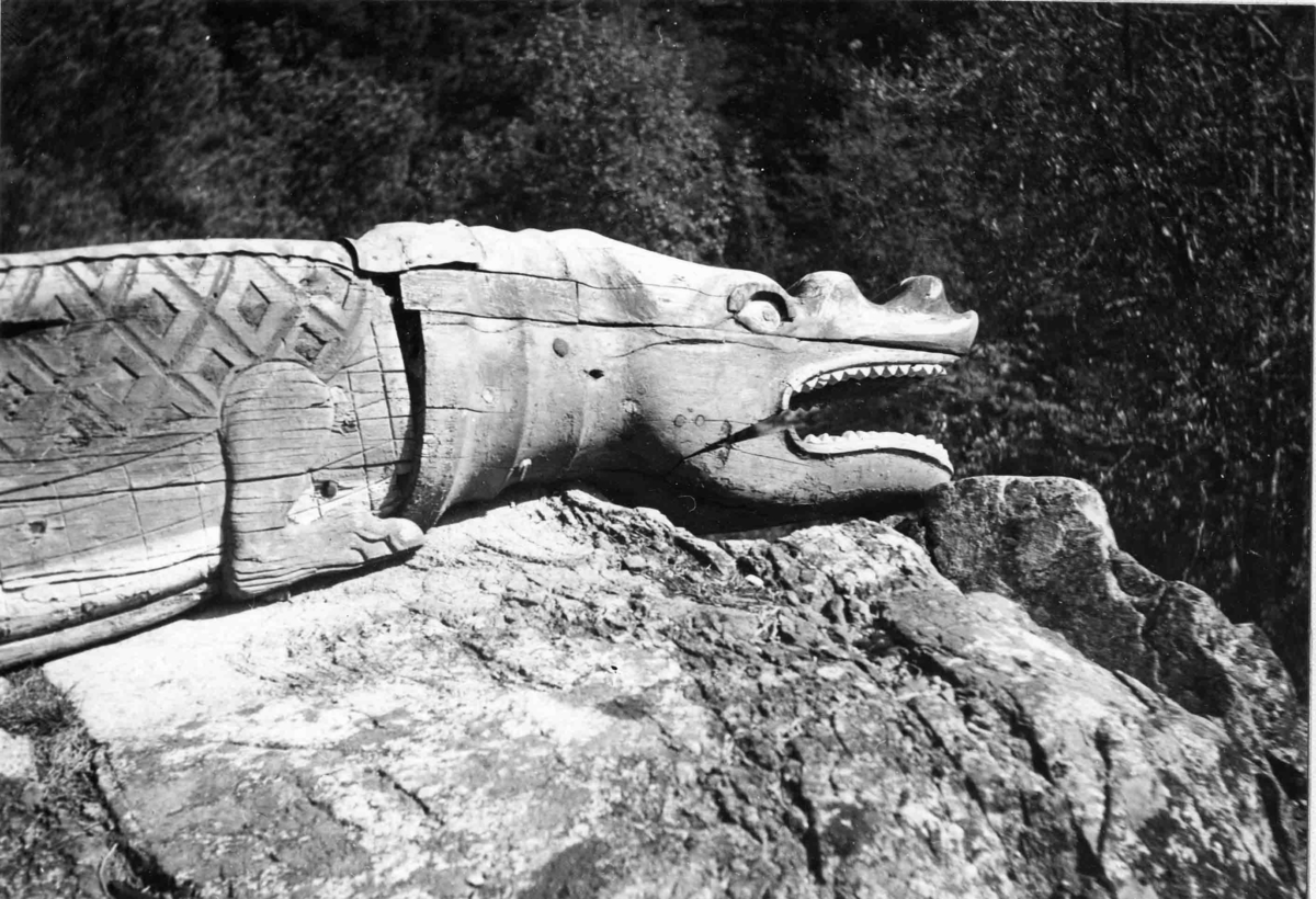 Alligator/krokodil med ett huvud och två sidor, som omslutit stäven. Öppen käft med sammanhängande tandrader och rombformade fjäll på ryggen. Målad i grönt och gult. Krokodilen består av flera delar, varav stora delar tidigare varit rejält angripna av röta. Huvud och höger sida är bäst bevarade.