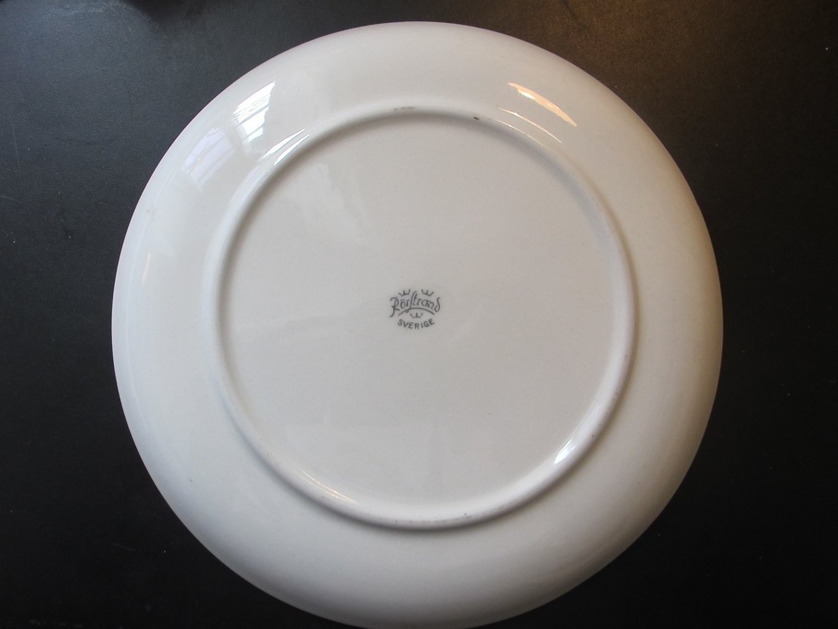 Minnestallrik med passagerarfartyget STOCKHOLM avbildat i tallrikens mitt. Text: "STOCKHOLM", "Göteborgs-Posten 1950".

Stämpel i tallrikens undersida: "Rörstrand Sverige"