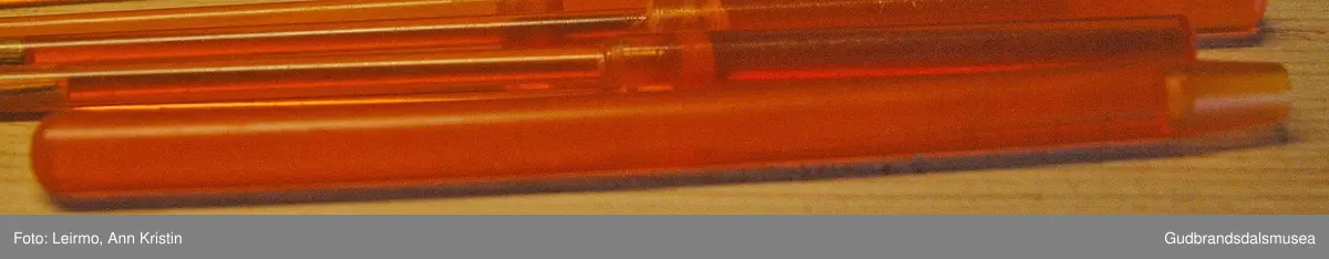Kvadratisk mappe i svart og rød plast, rund i kantene, har glidelås og blanke innerlommer hvorav to brede på den ene veggen og åtte smale lommer på den andre veggen. Til oppbevaring av småverktøy. Inneholder åtte små verktøy, blant annet et lite rundt inspeksjonsspeil i gul og oransje plast; til å se på trange plasser, flere små elektroskrujern som er flate i ene enden, slik å komme bedre til på plasser ved reparasjon. Håndtak laget i plast, slik unngår man støt. Det ene verktøyet kan ha funksjonenen som skrupipe, det vil si brukt til utvendig justering. Et lengre bøyd verktøy kan være et fleksibelt skrujern med bitsfeste, for utskifting av bits.