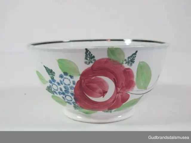 Dekorert med rosemøsnter. Blå rand langs kanten (innvendig). 