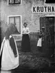 Kvinna framför Liljefors Kruthandel, Svartbäcksgatan 37, kvarteret Edda, Svartbäcken, Uppsala 1900 - 1901