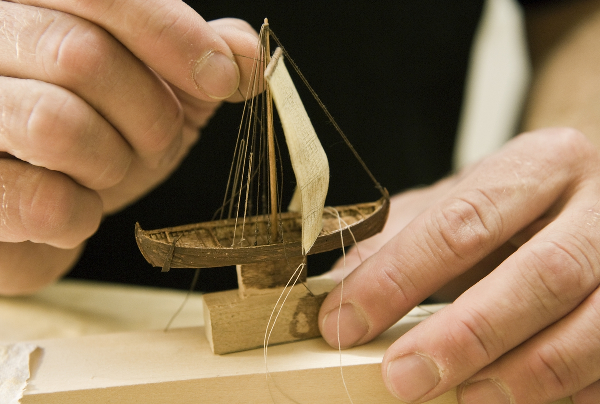 Modellbyggare Stefan Brun i arbete med en modell i skala 1:200 till utställningen "Shipping & Shopping".