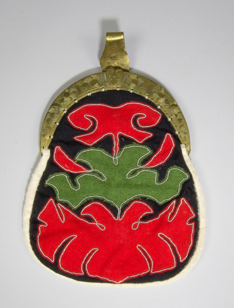 Kjolsäck till dräkt för kvinna från Delsbo socken, Hälsingland. Modell med bygel. Framstycke av svart ylletyg, kläde, med applikationer av rött och grönt ylletyg, fastsydda med tenntrådsbroderi. Motiv: i mitten en grön utklippt figur, omgiven upptill och nertill av röda figurer, alla med konturerna förstärkta med broderi. Foder av tryckt fabrikstillverkat bomullstyg, "persiskt" mönster i många färger. Kantad med remsa av vitt rakat fårskinn. Bakstycke av sämskskinn. Bygel med snäpplås och hake, båda med graverad dekor. Märkt på haken med gravyr: B.E.D.