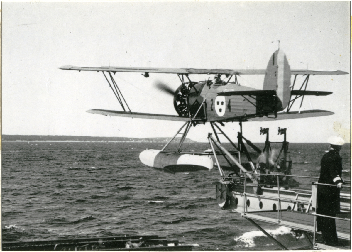 [från Fotobeskrivning:] "Flygplankryssaren GOTLAND. Flygplan S 9 utskjutes från katapulten." Vid genomlysning kan handskriven text på kopians baksida skönjas men inte tydas.