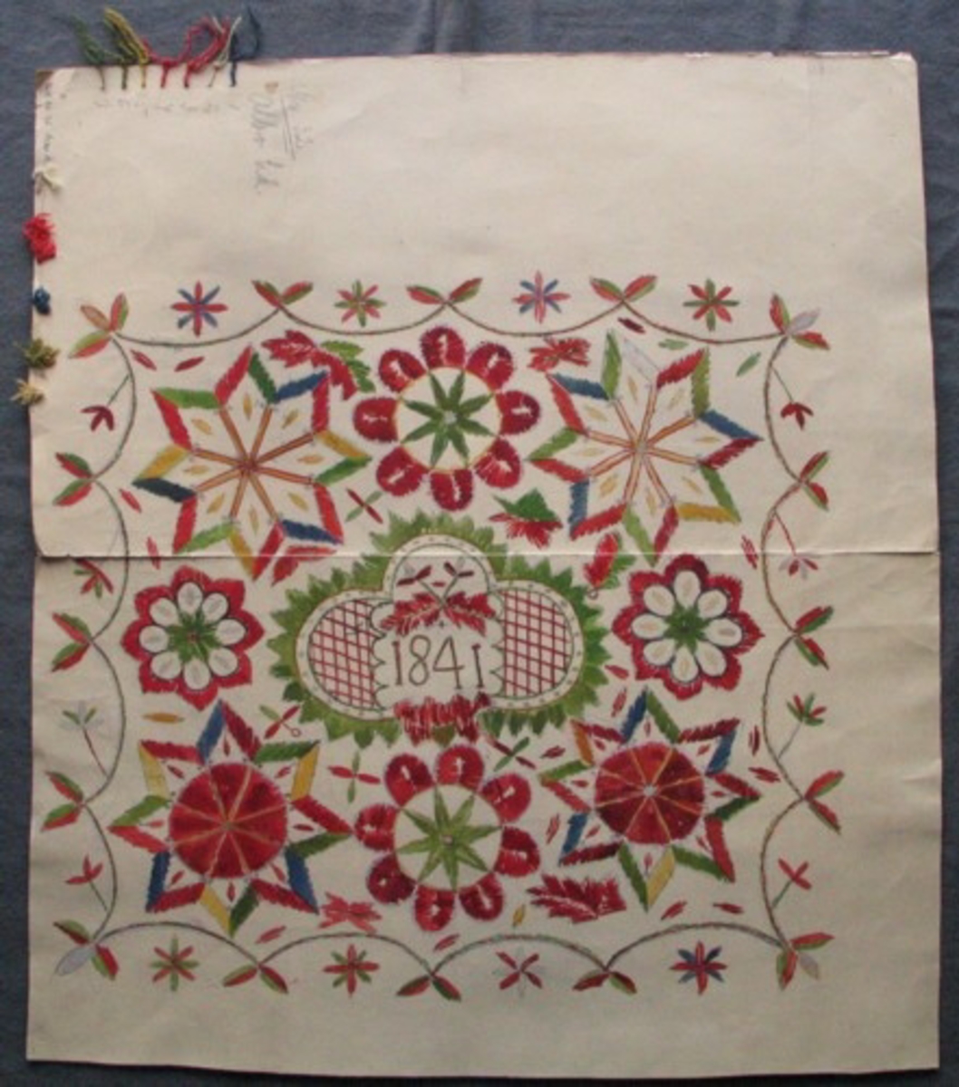 Skiss i vattenfärg av hel hudde, på styvt papper. I mitten ett ornament med årtalet 1841. Stora stjärnor i hörnen, något mindre stjärnor på långsidorna. Bård av bågformadl linje. På två av sidorna stjärnor de andra två sidorna små blommor. Två olika uppsättningar med garnprover i ena hörnet. Gammal märkning: "Nr 32, Albo hd".