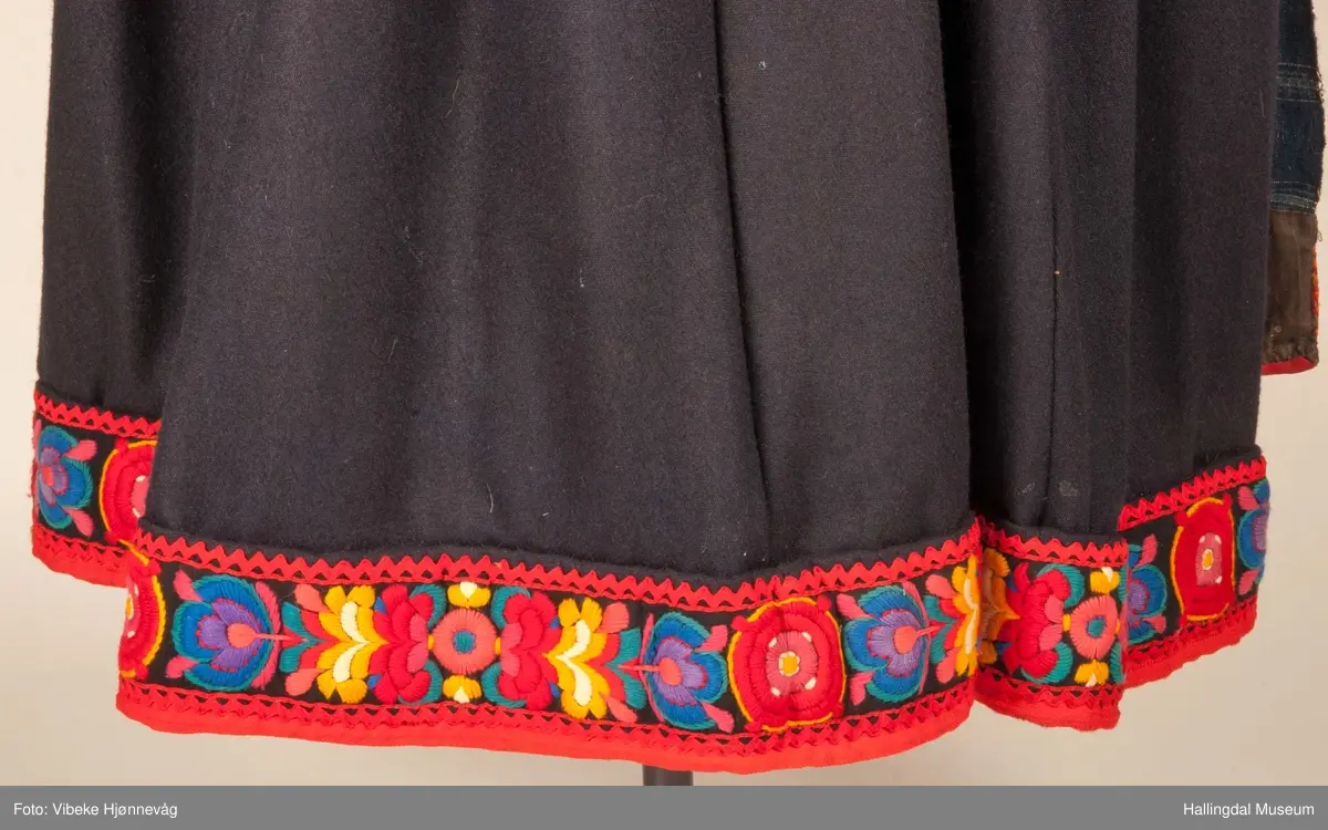 Kone fra Nedre Hallingdal i hallingbunad.  Kona står utstilt i den faste bunadutstillingen på Hallingdal Museum, Nesbyen.  Hallingbunaden består av mange draktdeler; trøya HFN 01835, Forkle HFN 03381, stakk, liv, lue, silketørkle rundt lua, silketørkle rundt halsen HFN 03500, bringduk og skjorte.
