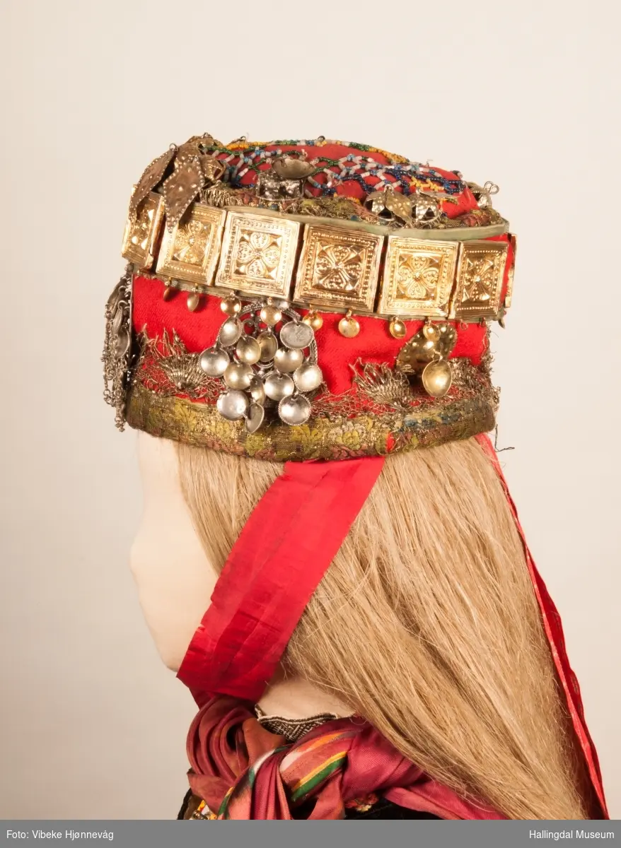 Drakten står utstilt i den faste bunadutstillingen på Hallingdal Museum, Nesbyen.  Den ble satt opp på grunnlag av et bilde fra Norsk Folkemuseum, tatt ang. av Axel Lindahl.  Tidfestet til 1877-78.  Høyde på overdel ble bestemt etter lengden på trøya.  Utelatelsen av det store bryststykket og andre forandringer ble diskutert med Ågot Noss og godkjent.  Ny dokke ble bygd opp med utgangspunkt i stakkens mål.
HFN 03387-stakk med liv.  Stakk og liv ble skilt 5.1.1999, rød ulltråd med tråklesting festet delene sammen, fjernet.  Stakk festet til liv i ny høyde med store attersting med rødt bomullsgarn.  Det ble sydd understakk i ubleket lerret med vattering av dacronvatt, for å få riktig profil.
HFN 03386 Forkle er noe for kort.
HFN ? Skjortering, sydd fast i skjorta.
HFN 00677 sølje, sydd fast i skjorta.
HFN 00533 sølje sydd fast i skjorta.
HFN ? Perleklut, sydd fast i skjorta.
HFN 00560 Angus Dei, påsatt ny silkesnor.
HFN 06695 Silketørkle, blått, festet i forklesnora
HFN 03499 Silketørkle festet i forklesnora
HFN 06694 Silketørkle, rødt rundt halsen
HFN 03603 Brudelue
HFN 03137 Stølebelte, påsatt bendelbånd, disse ligger over skuldrene for å holde beltet oppe.
HFN 03318 Linskjorte.  Vasket: desember 2000
HFN 01815 trøye i svart speilfløyel.