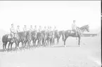 Avlämning för utbildning i ridning. Klädsel: uniform m/10, mössa m/1895. Hästarna betslade med kandar och sadlade med filt.