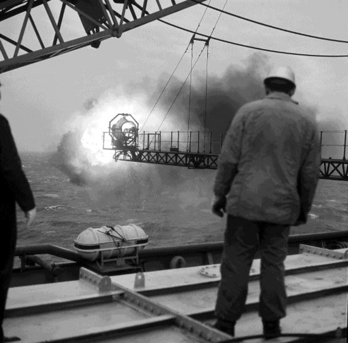 To menn studerer en flammebom på boreplattformen "Gulftide".