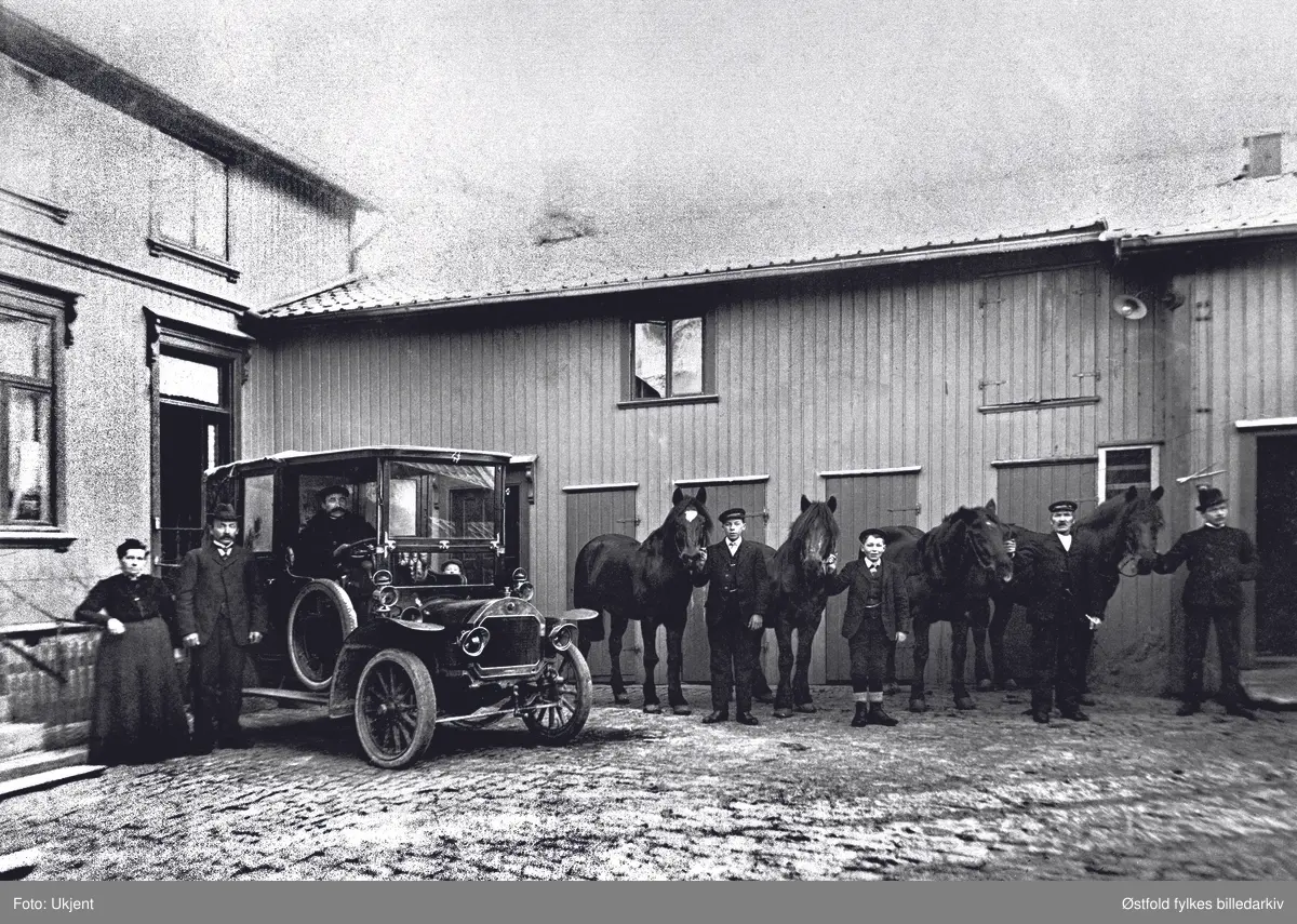 Gruppebilde av vognmann Eriksens bedrift med ansatte, hester og bil i Glemmengata 36 i Fredrikstad ca. 1910-15.
Vognmann Johannes Eriksen hadde  forretning der, personene til venstre er Karin Bolette og Johannes Eriksen.


Bilen er en Unic, levert av Kolberg, Caspary & Co i 1910.  Den var tidligere registrert på Kristiania 122.  Johannes Eriksen hadde kjøretillatelse nr. 433a i Kristiania, utstedt 23.5.1910. Vognmand Eriksens forretning lå i Glemmengata.