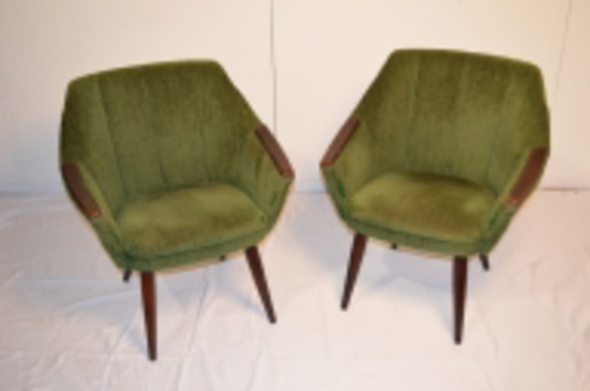 To lenestolar trekt i grønt stoff. Plankar på armlena. Stoffet er slitt og forsøkt reparert med ein tråd i ein mørkare grønfarge enn stolane.
