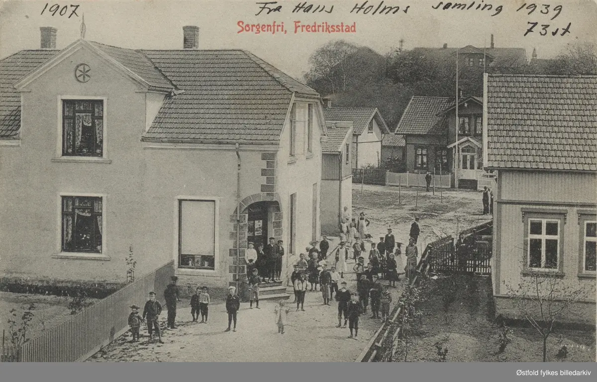 Gateparti fra Sorgenfri 1905. Murbygning som ser ut til å ha en hjørnebutikk, skilt som ser ut som "Skallebakke (?)". Masse barn på utsiden av butikken. Postkort.

Butikken på bildet er idag Lurvelegg barnehage som ligger i Galtungveien på Sorgenfri. I bakgrunnen skimtes  gamle Sorgenfri gård. Husene ved veien bak er  til venstre Bruksgata 6. Huset med flaggstangen ved siden av er Bruksgata 4.