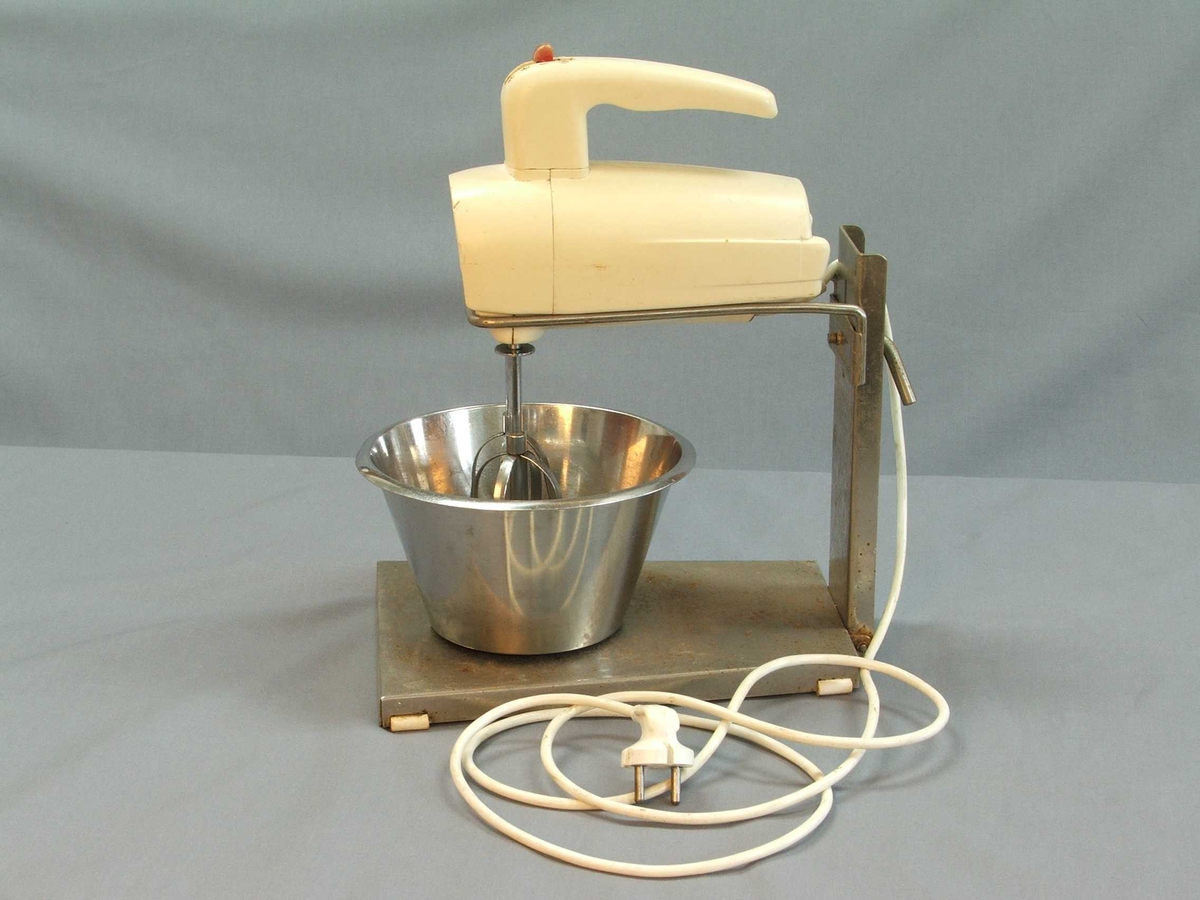 Miksmastar i fem delar: Stativ, bolle, maskin med leidning, to vispar. Stativet er av stål, her kan bollen stå oppå og maskinen stå ned i ei råme med vispane ned i bollen. Bollen er i rustfritt stål. Maskinen er tung, handtak øvst, knapp med fire trinn også øvst. Uttak til vispar under. Vispar samansett av to ovalar med stålband.