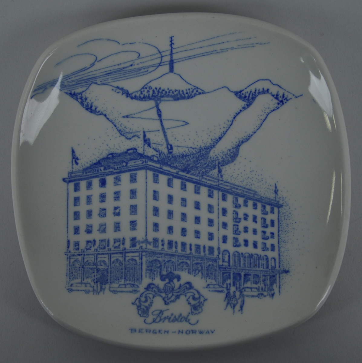 Stor klassisistisk bygning, Hotel Bristol, Bergen, i framgrunnen med fjell og toppen Ulrikken med sendemast i bakgrunnen.