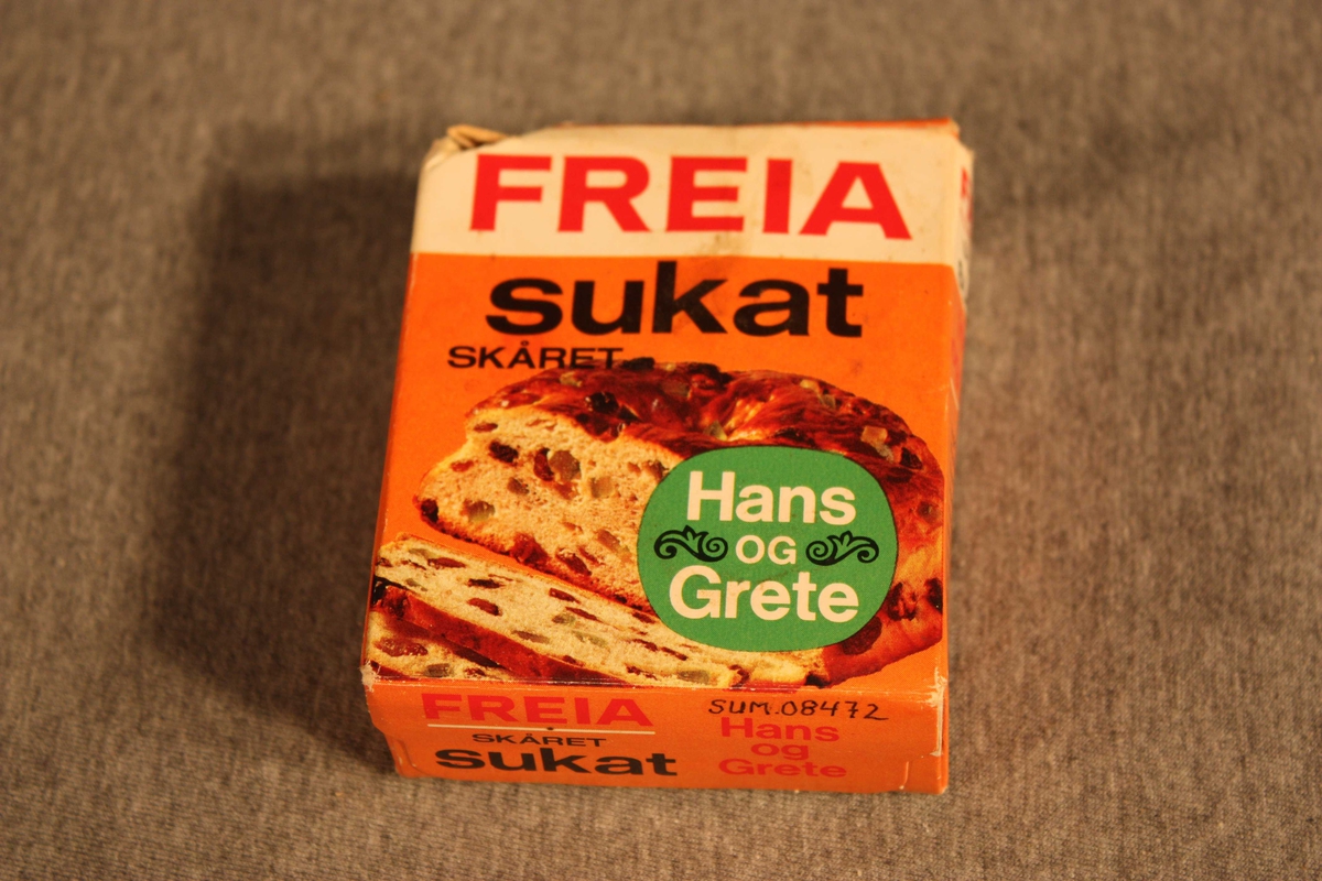 Originalpakning med sukat, opna og brukt av. På framsida bilete av brød med sukat og rosiner, på baksida oppskrifter.